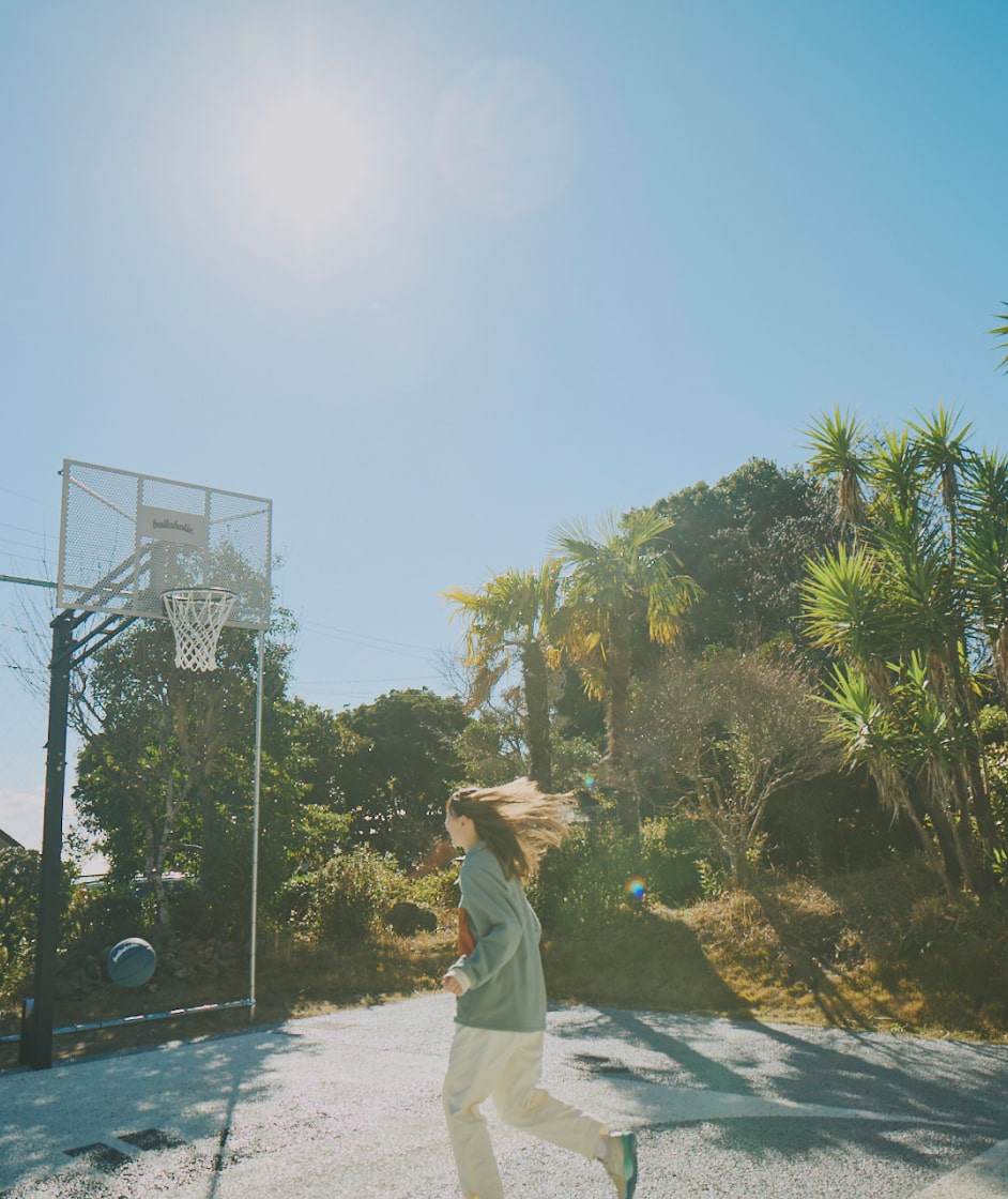 屋外でバスケットボールをする女性