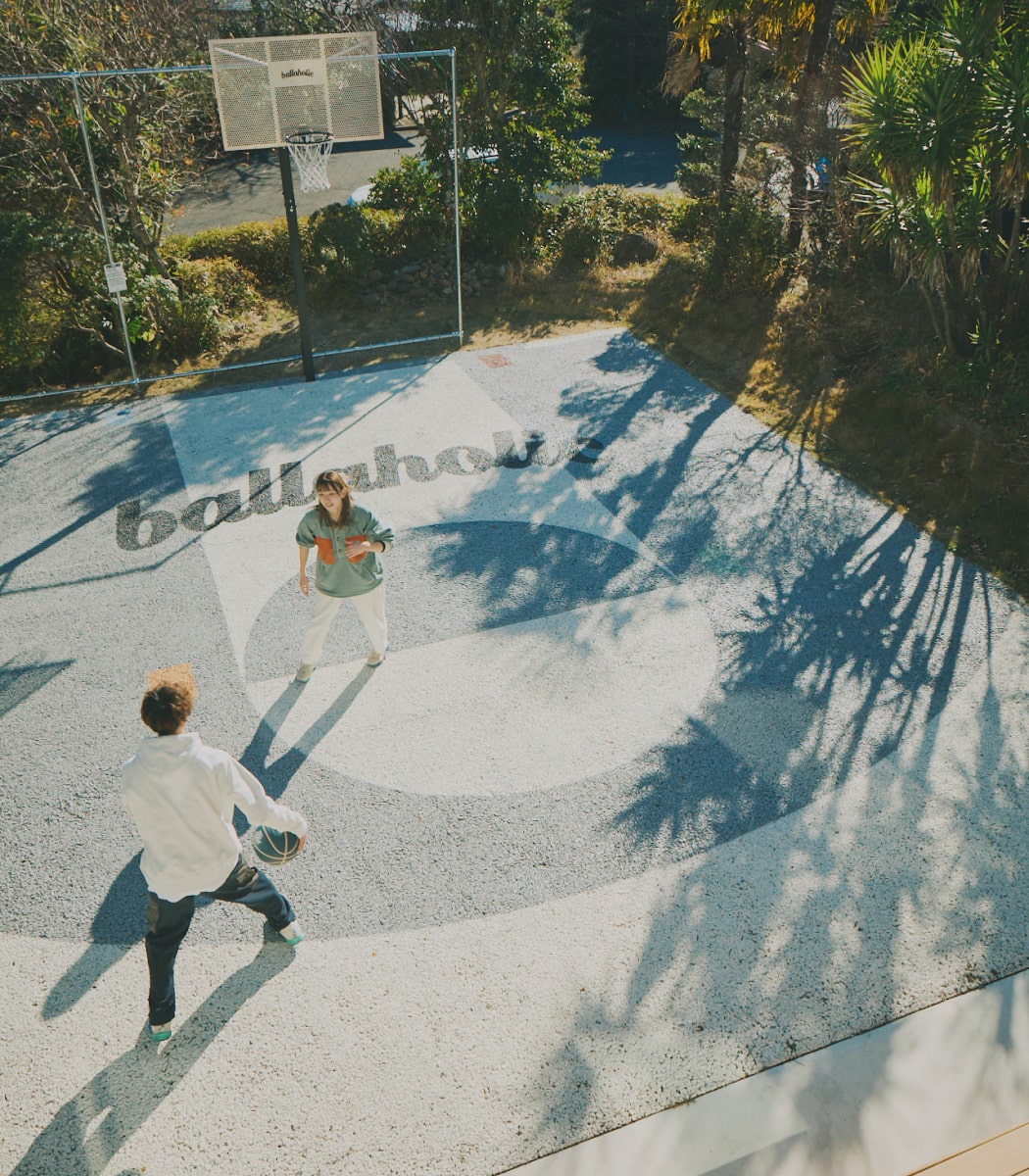 屋外でバスケットボールをする男女