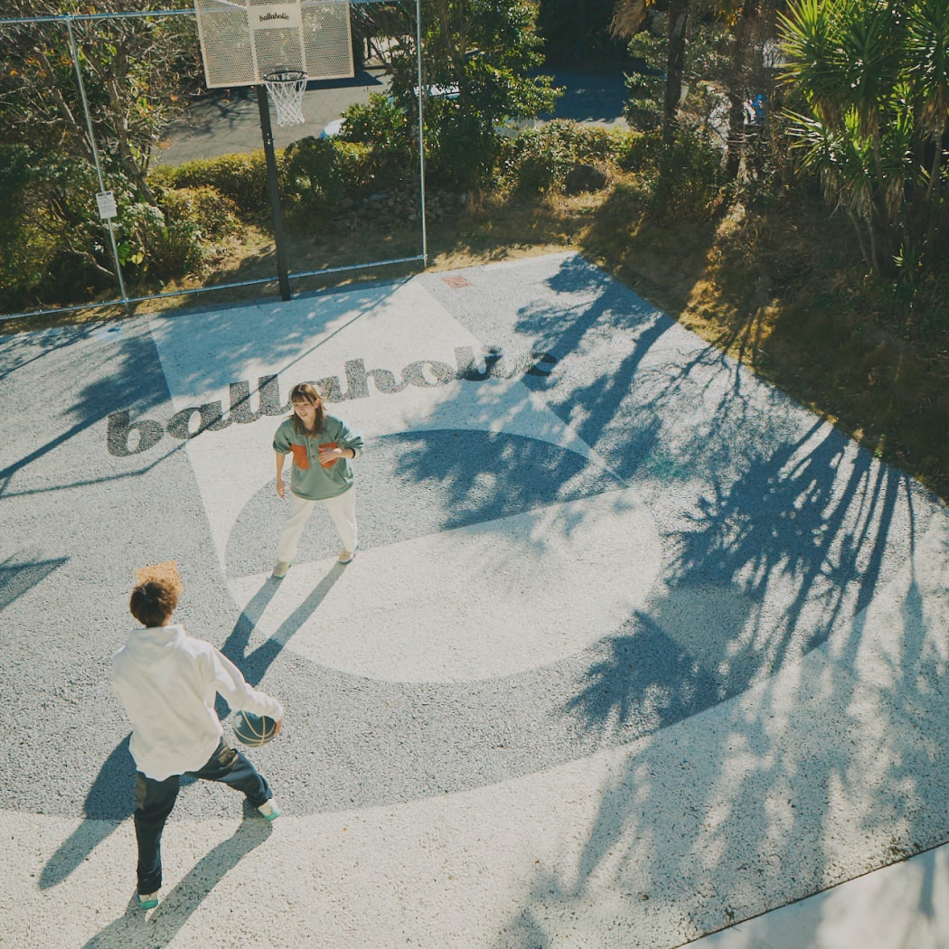 屋外でバスケットボールをする男女