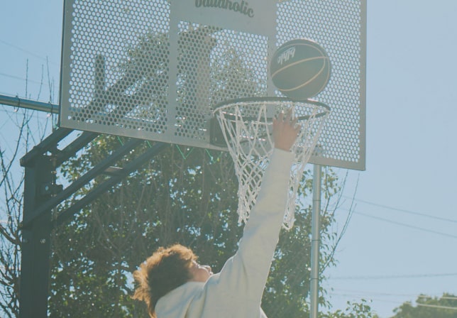 バスケットゴールにシュートする男性